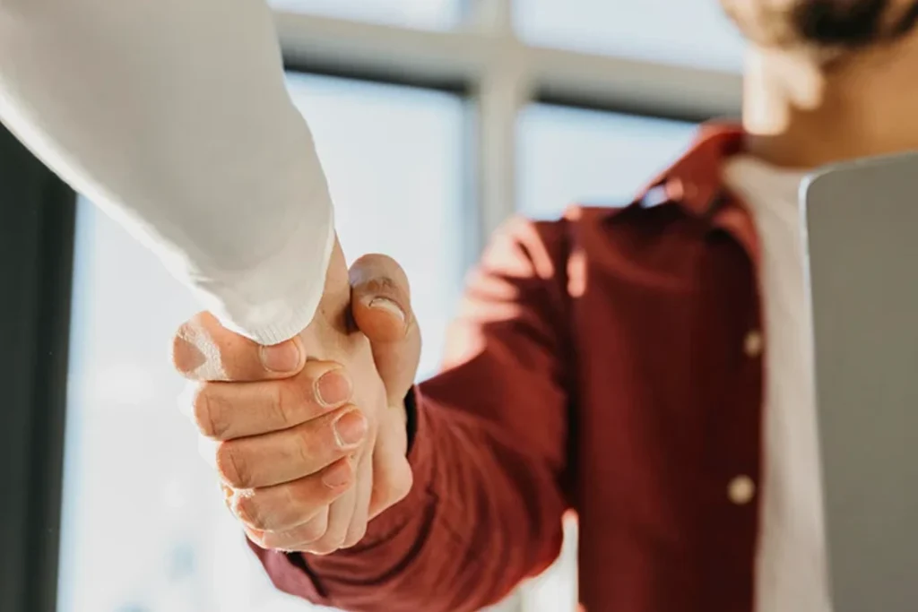 Zwei Personen geben sich die Hand als Zeichen für erfolgreiche Zusammenarbeit in der Getränkelogistik