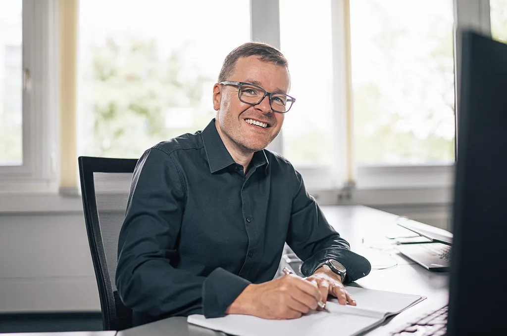 Geschäftsführer Mirco Jacob bei der Arbeit im Büro, zentrale Rolle im Team