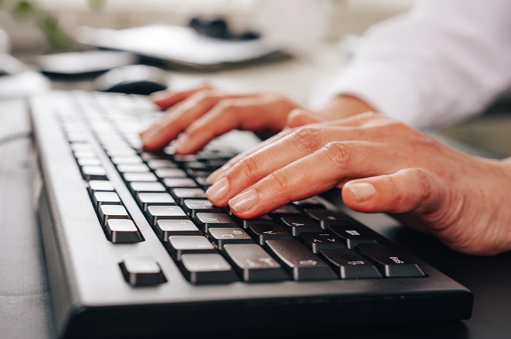 IT-Service Mitarbeiter tippt auf einer Computertastatur im Büro
